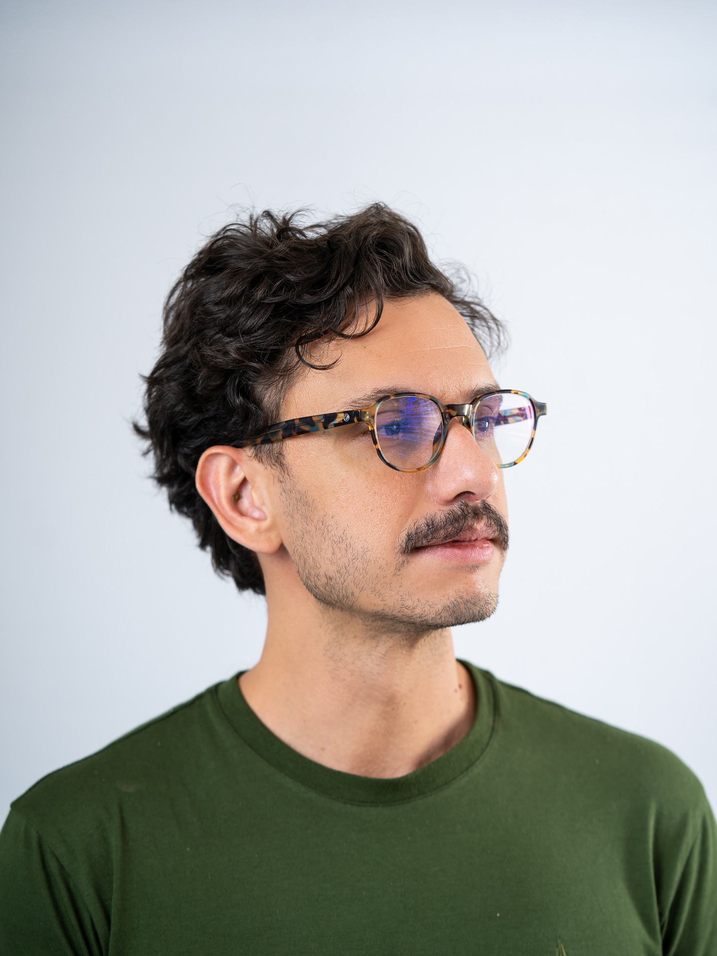 Pedro Henrique Monteiro, artista plástico brasileiro de Goiânia, retrato com óculos e camiseta verde